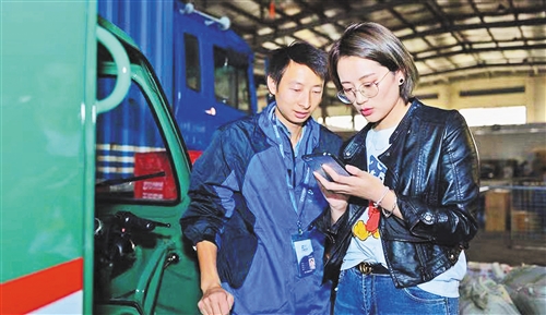 方美婷（右）和快递员交流菜鸟语音机器人的使用感受。使用菜鸟语音机器人之后，快递员的配送效率和服务质量都得到了提高。