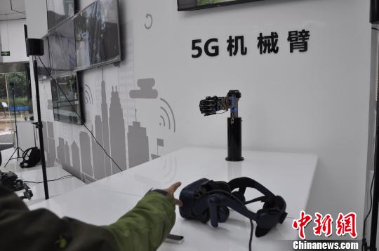 通过5G网络,机械臂可以对外界信息及时反馈。图为体验者与机械臂玩石头剪子布游戏。 陈茂霖 摄 通过5G网络,机械臂可以对外界信息及时反馈。图为体验者与机械臂玩石头剪子布游戏。 陈茂霖 摄